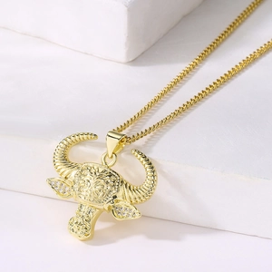 Detailed macro view of 18K gold bull head pendant with zircon on white stone