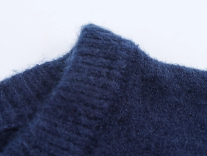 Detailed macro view of dark blue ribbed knit neckline showing soft mohair wool texture