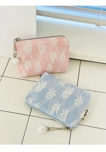 Close-up of pink and blue lace coin purses with floral patterns and pearl ornaments