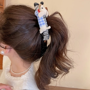Detail of fabric dachshund dog hair clip with blue and black checkered patterns on ponytail