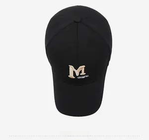 Top down view of black cotton baseball cap showing detailed white 3D letter M embroidery