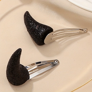 Détail de pinces à cheveux cornes de diable noires pailletées avec clips en métal argenté