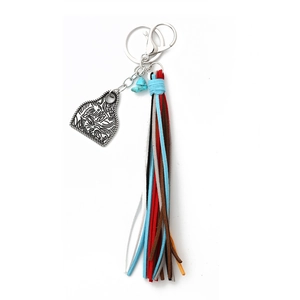 Detail of western style keychain with carved bull tag, colorful suede tassels and turquoise
