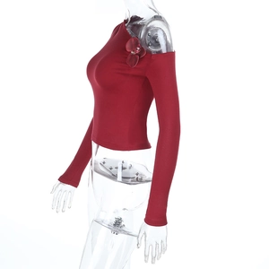 Close-up of dark red off-shoulder top with 3D rose detail and stretchy fabric texture