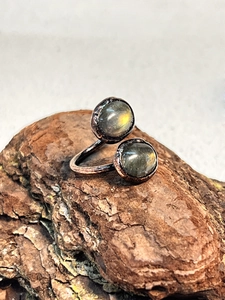 Detail of vintage copper ring with labradorite stones and hammered texture on bark