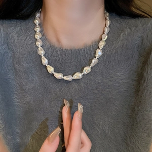 Close-up of Baroque pearl necklace with irregular shapes on a grey sweater