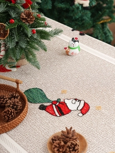 Close-up of rustic grey polyester lace tablecloth with Santa Claus embroidery detail
