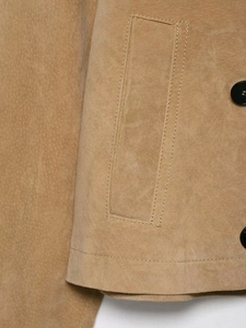 Detailed close-up of khaki suede jacket featuring precision stitching and black buttons