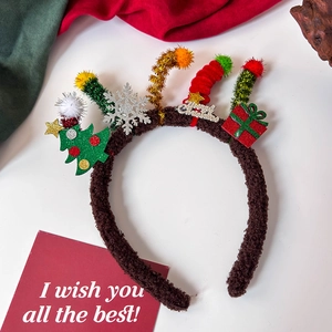 Detail of plush Christmas headband with green tree, red gifts and silver Merry Christmas sign