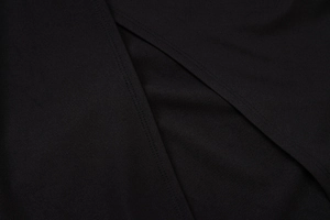 Close-up macro view of the black fabric texture and professional stitching on the dress