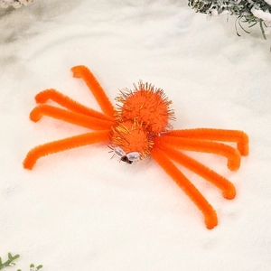 Detail of orange fuzzy Halloween spider hair clip with bendable legs and googly eyes