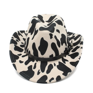 Close-up of cow print felt hat featuring a black decorative band and metal floral buckle