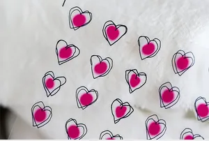 Macro detail of 5D heart-shaped nail art stickers with pink dots and black outlines