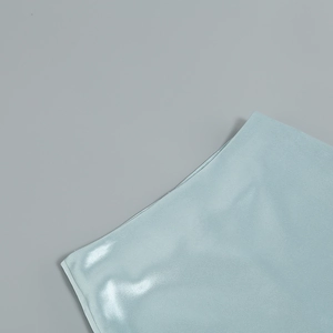 Détail macro de la taille d'une jupe en satin bleu clair avec texture en soie et fini brillant