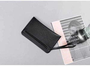 Detail of black pebbled leather clutch bag featuring front zipper pocket and wristlet strap