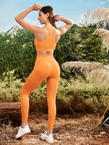 Close-up of bright orange fitness set showing breathable mesh texture and knit fabric detail