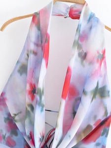 Detail of colorful floral print midi dress featuring a halter neck and lightweight fabric