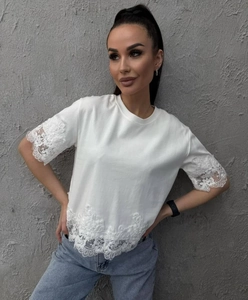 Primer plano detallado de camiseta blanca con ribetes de encaje en mangas y dobladillo
