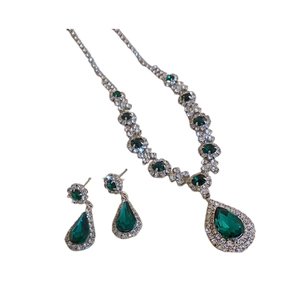 Vintage jewelry set with emerald pear-cut necklace and crystal drop earrings on white background