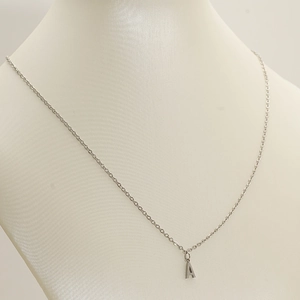 Detailed close-up of a silver initial A pendant on a stainless steel clavicle chain