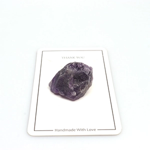 Macro detail of natural raw amethyst stone crystal specimen on a display card