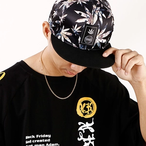 Close-up of a model wearing a slim gold Cuban chain necklace with a black graphic tee