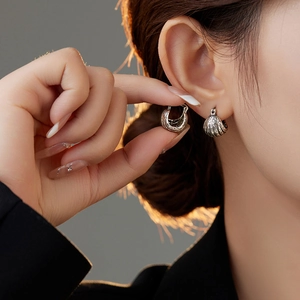 Silver vintage lava texture hoop earrings with embossed horseshoe design on model