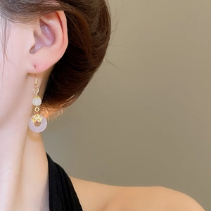 Détail d'une boucle d'oreille en calcédoine avec jade rose et décor de nuage doré