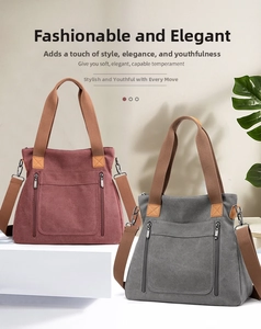 Detail of burgundy and grey canvas tote bags with leather patches and dual zipper pockets