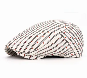 Detail of light khaki beret cap with black stripes and small red embroidered hearts