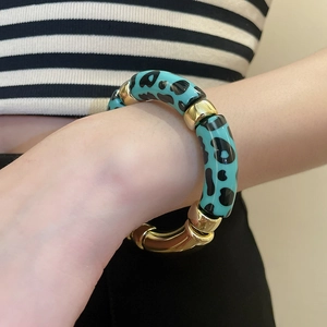 Gros plan détaillé d'un bracelet extensible en acrylique léopard bleu sarcelle et métal doré