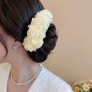 Elegant cream floral hair pin accessory worn on hair for a graceful wedding or daily look