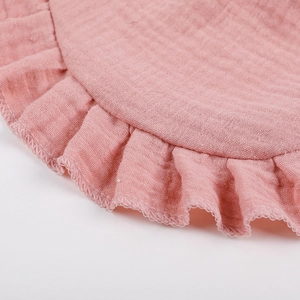 Macro detail of pink ruffle trim on double-layer cotton gauze baby bib fabric
