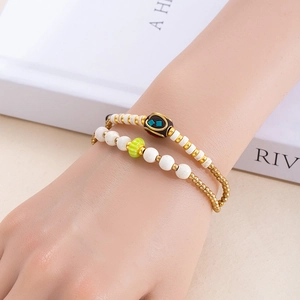 Détail de bracelets perlés ethniques empilés avec accents dorés et pierres turquoise