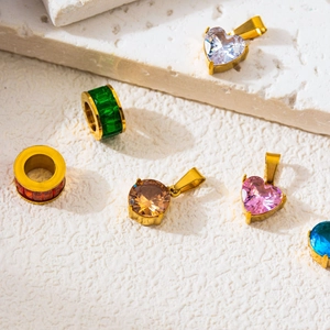 Golden DIY jewelry pendants with colorful zircons on natural stone decorative background