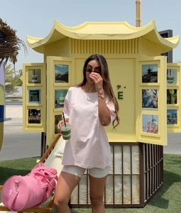 Outdoor shot of an oversized pink T-shirt featuring 'Just Have' chest print and drop shoulders