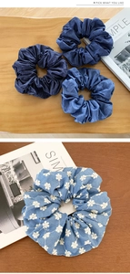 Detail of blue denim scrunchies with white rose embroidery on high elastic hair bands