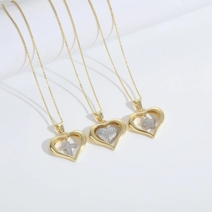Three gold heart necklaces with cross, heart, and star zircon pendants on white background