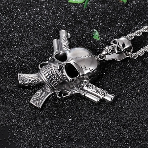 Macro shot of silver punk skull and dual guns pendant on a textured black background
