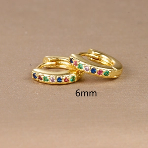 Detail of 6mm 18K gold huggie earrings featuring multi-color rainbow cubic zirconia
