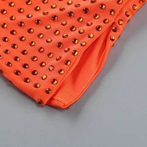 Gros plan sur la maille côtelée orange avec strass assortis et détails de couture fins