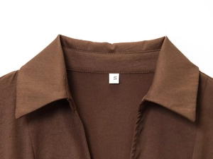 Detalle del cuello de solapa marrón y costuras finas con etiqueta de talla S en el vestido