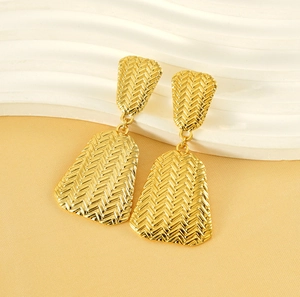 Detail of 18K gold stainless steel earrings with intricate woven texture and geometric design
