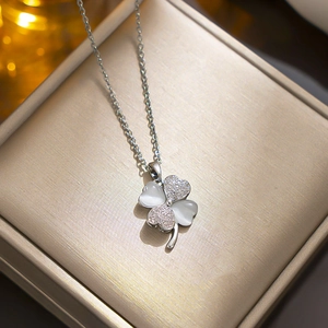 Elegant silver four-leaf clover necklace with cat eye stones and sparkling zircons