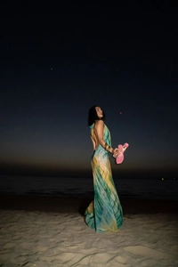 Detail of bohemian tie-dye maxi dress with halter backless design on a night beach