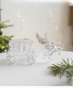 Detailed view of a clear acrylic pumpkin carriage ornament with silver glitter on wings