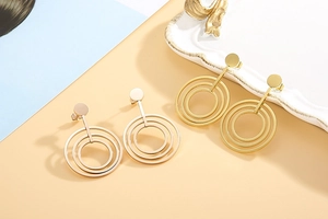 Macro detail of triple geometric hoop earrings in rose gold and yellow gold finish