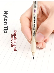 Close-up of hand holding a professional waterproof drawing pen on lined paper