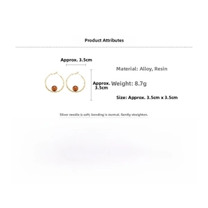 Detailed view of gold alloy hoop earring with brown resin bead and size specifications