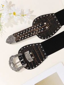 Close-up of vintage wide elastic belt featuring silver carved buckles and crocodile texture